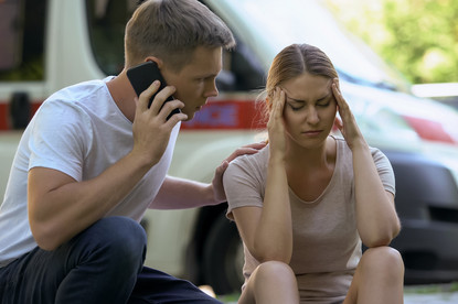  Eine Frau sitzt am Boden und ein Mann telefoniert.