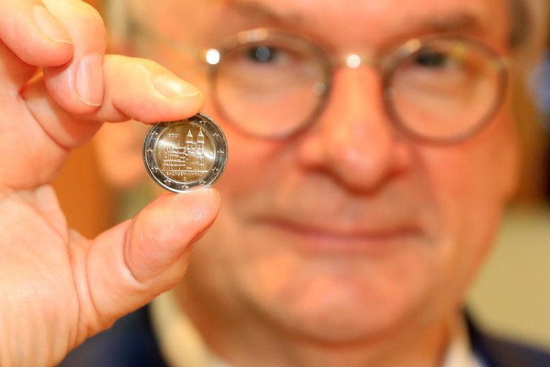 Bundesratspräsident Dr. Reiner Haseloff hält die Gedenkmünze in der Hand.