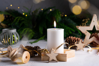 Eine angezündete Kerzt neben Dekoartikel