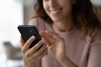 Das Bild zeigt eine Frau mit einem Handy.