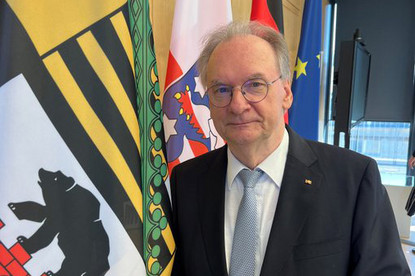 Ministerpräsident Dr. Reiner Haseloff neben der Sachsen-Anhalt-Fahne.