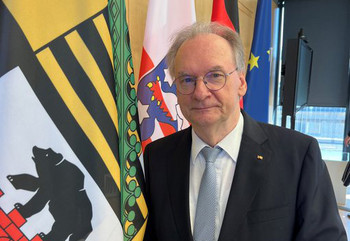 Ministerpräsident Dr. Reiner Haseloff neben der Sachsen-Anhalt-Fahne.