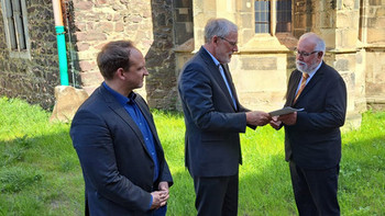 Kulturminister Rainer Robra übergibt den Förderbescheid für die Walloner Kirche in Magdeburg.