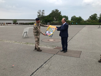 Das Bild zeigt Ministerpräsident Dr. Reiner Haseloff und einen Soldaten bei der Übergabe der Sachsen-Anhalt-Flagge.