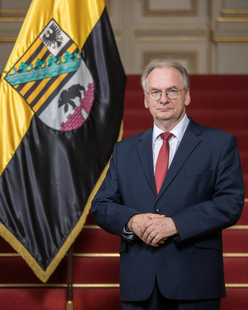 Das Bild zeigt Ministerpräsident Dr. Reiner Haseloff neben der Sachsen-Anhalt-Fahne.