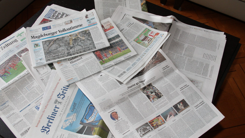 Das Bild zeigt einige Zeitungen.