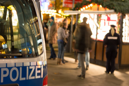 Das Bild zeigt die Polzei auf einem Weihnachtsmarkt.